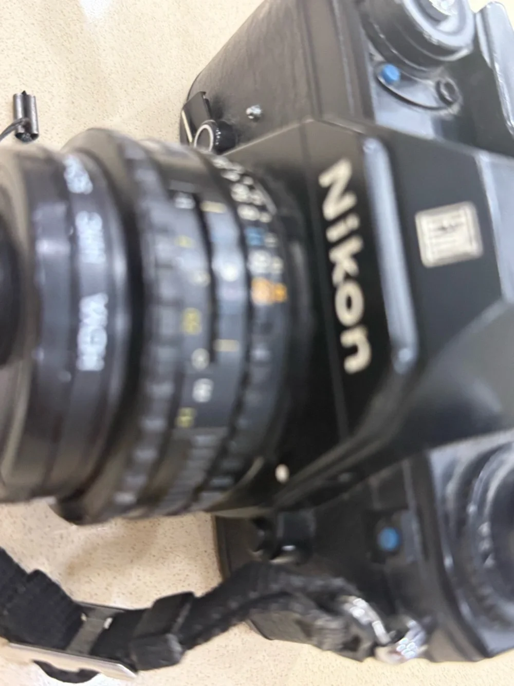 Nikon Black 35mm SLR Camera with Attached Lens and Strap
